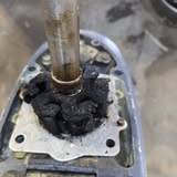 Metal tube rising from a plate on top of an outboard leg, surrounded by thick black buildup